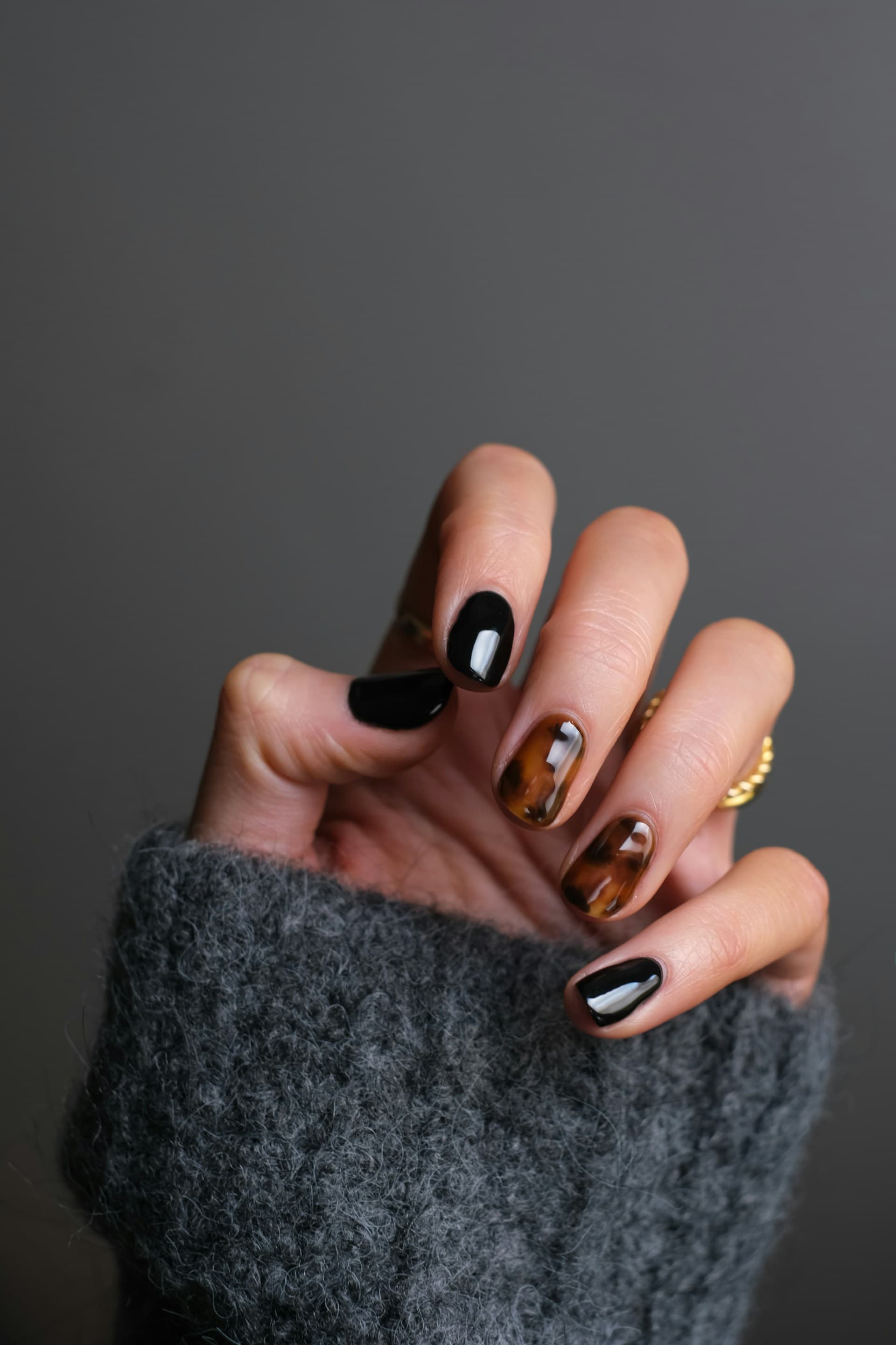 Detailed nail art with black and amber polish